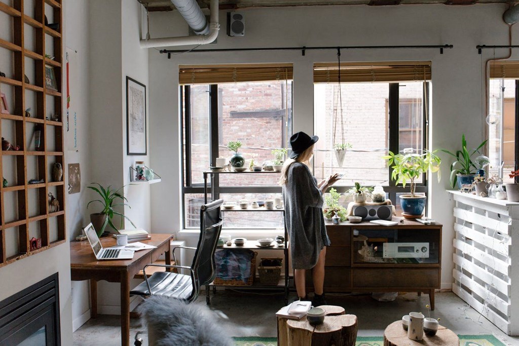 a woman standing in a living room looking out a window