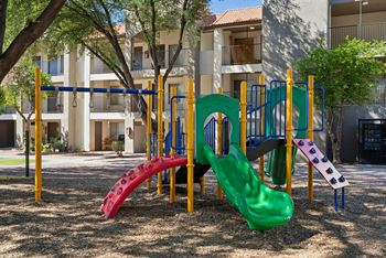A playground with a red, green, and blue slide.