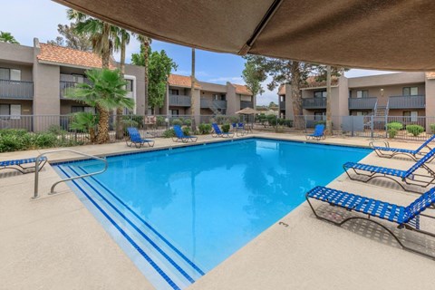 A large swimming pool with blue water and a metal diving board.