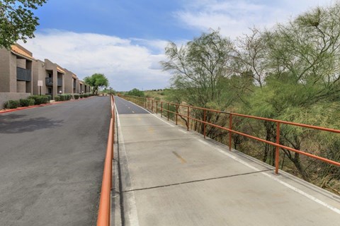 A long road with a metal railing on the side.