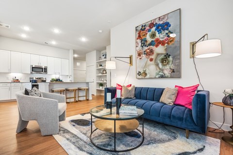 A living room with a blue couch and a grey armchair.