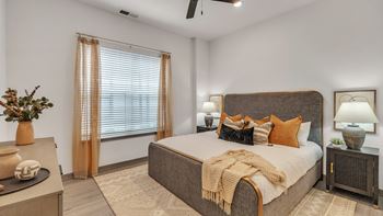 A bedroom with a large bed and a ceiling fan.