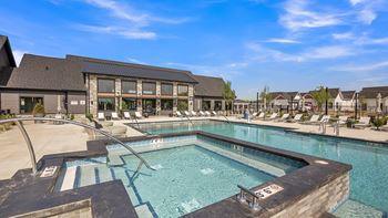 A large outdoor swimming pool with a diving board and lounge chairs.