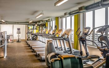 A gym with treadmills and elliptical machines.
