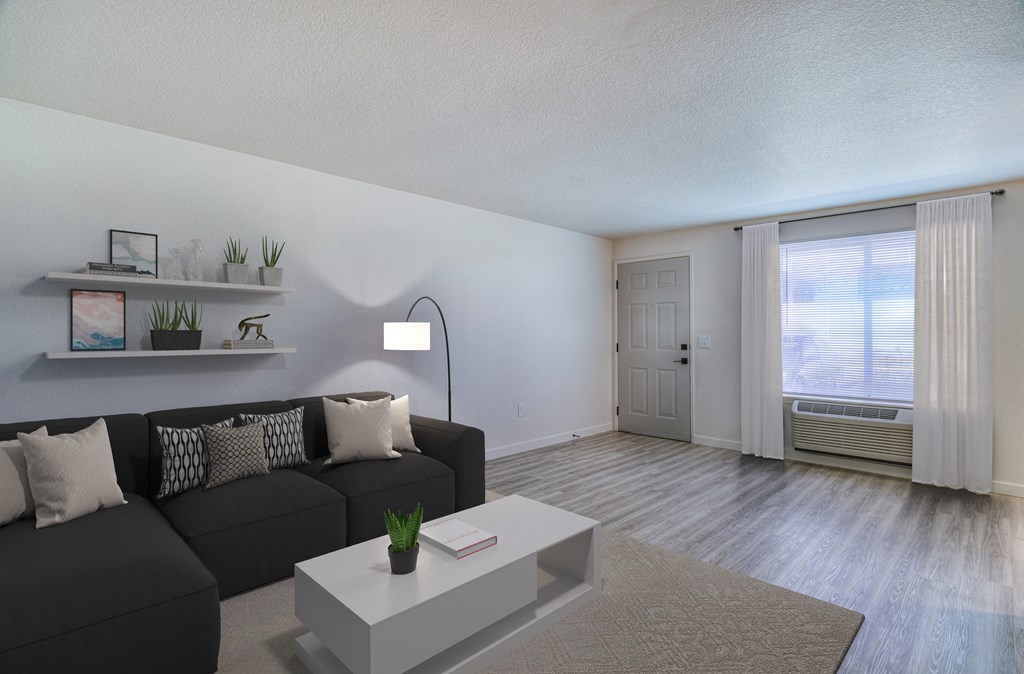 a living room with a black couch and a white coffee table