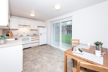Fox Pointe Apartments Model Kitchen and Dining Room with Patio Door - Photo Gallery 8