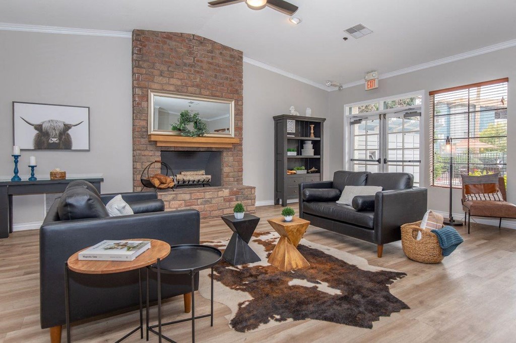 A living room with a fireplace and a cow picture on the wall.
