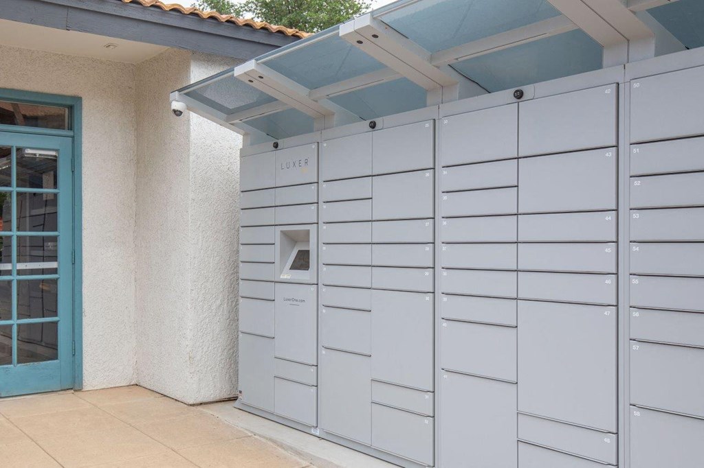 A series of mailboxes are lined up on the side of a building.