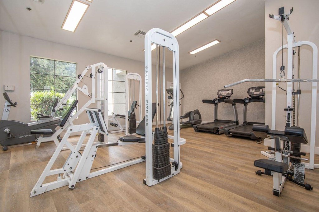A gym with a variety of equipment including a leg press machine.
