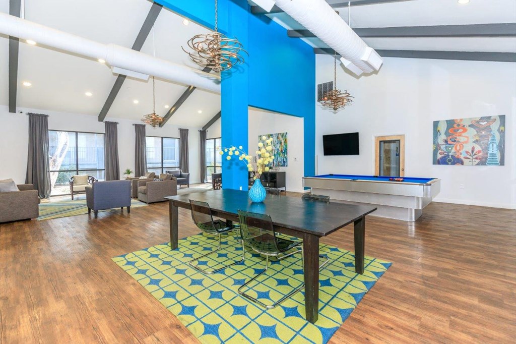 A blue and yellow patterned rug sits on a wooden floor in a room with a pool table.