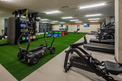 A gym with a variety of equipment including a rowing machine.
