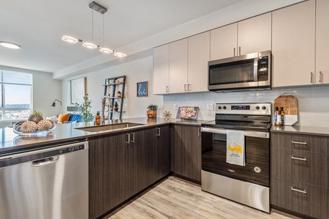 a modern kitchen with stainless steel appliances and white cabinets