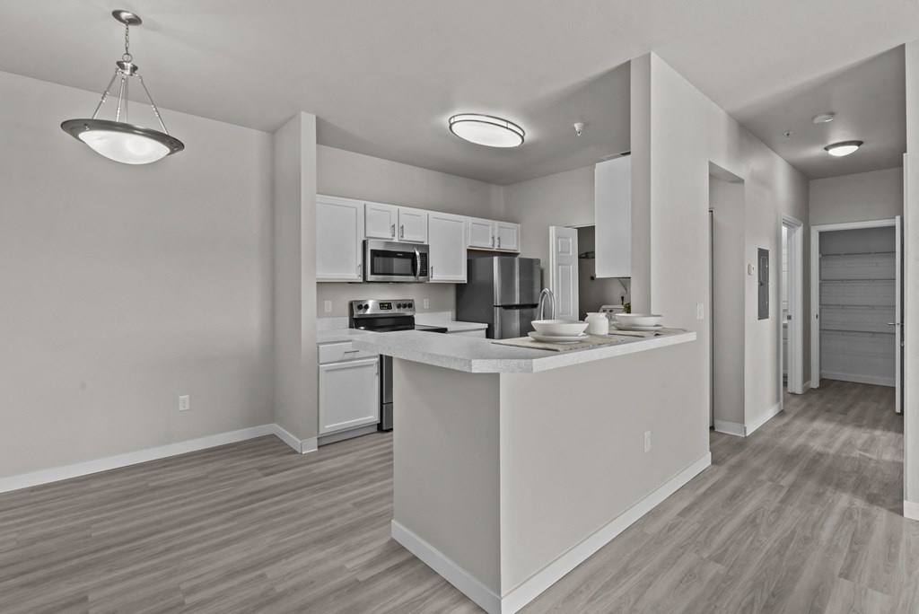a kitchen with white cabinets and a white counter top in a apartment