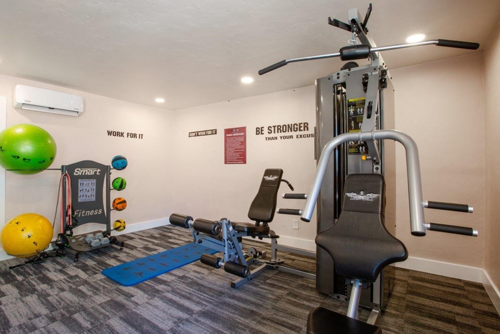 A gym with a variety of equipment including a leg press machine.