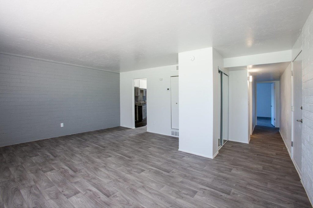 A room with wooden flooring and white walls.
