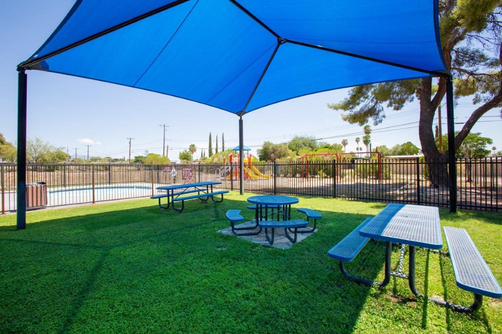 A blue canopy is over a picnic table.