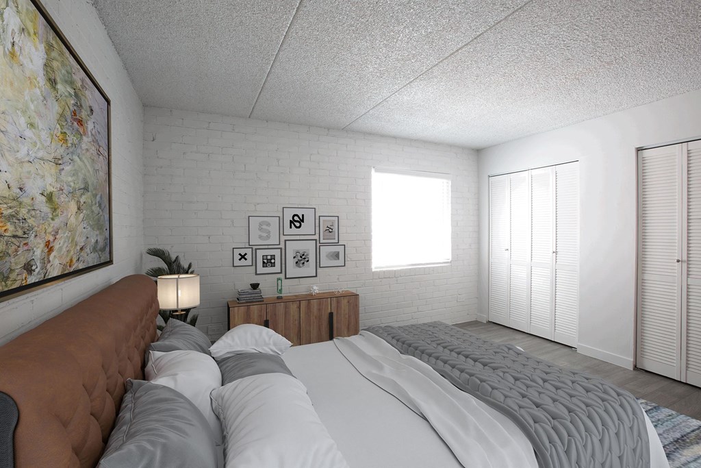 A bedroom with a large bed and a brown couch.