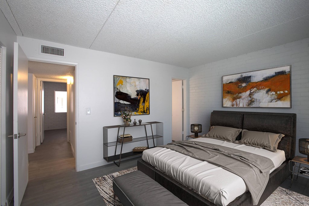A bedroom with a large bed and a painting on the wall.