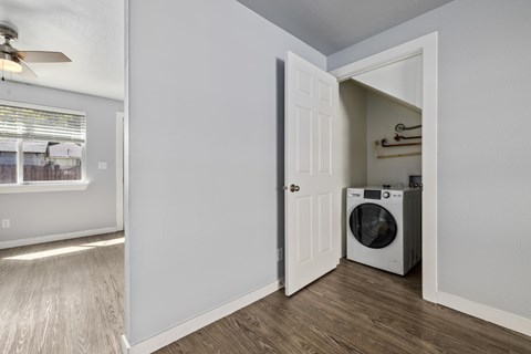 the living room of an apartment with a washer and dryer