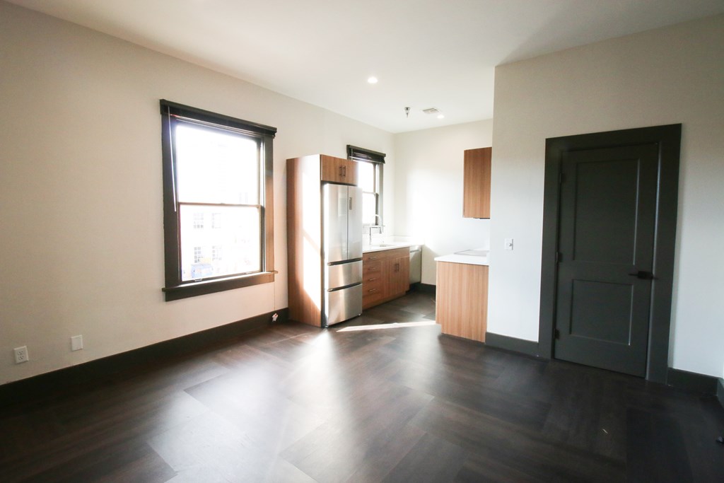 A room with a black door and a window with a white frame.