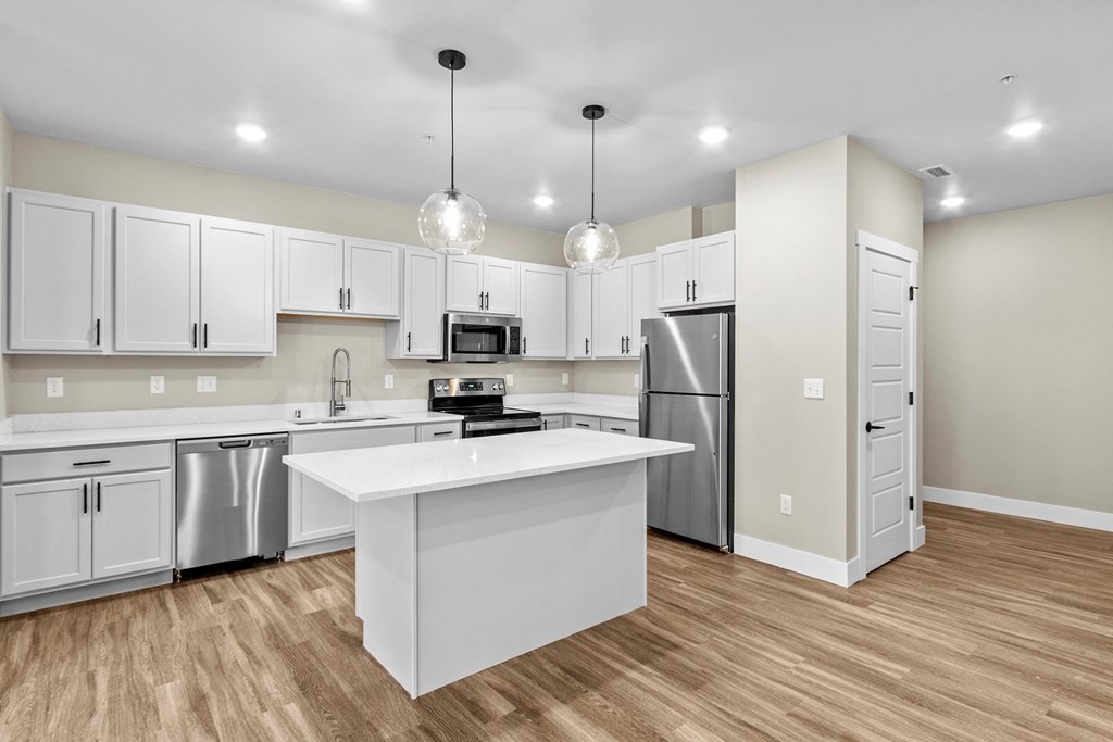 a kitchen with white cabinetry and a white island with a white countertop