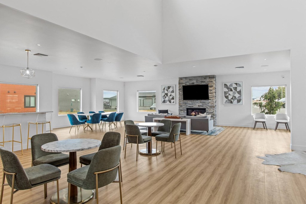 a common room with tables and chairs and a fireplace