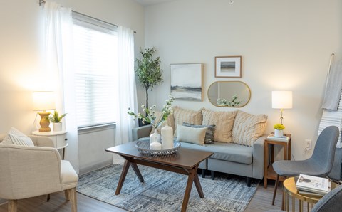 A living room with a grey couch, a wooden coffee table, and a grey armchair.