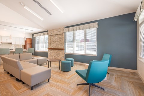 A room with a blue chair and a tan couch.