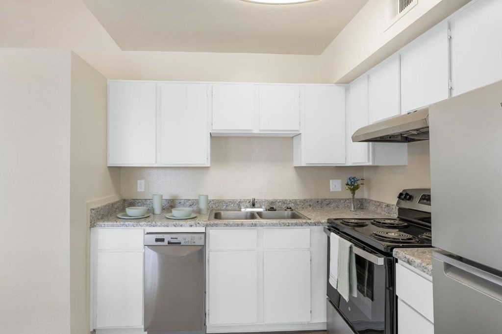 A kitchen with white cabinets and appliances.