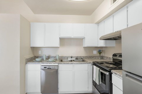 A kitchen with white cabinets and appliances.