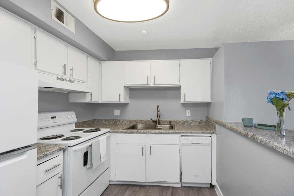 A kitchen with white appliances and cabinets.