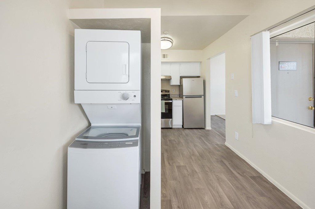 A white dishwasher is in a kitchen with a white oven.