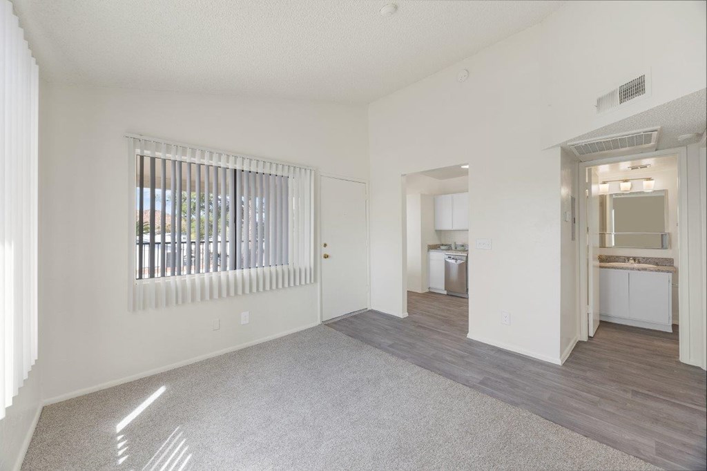 A spacious living room with a large window and a view of the outdoors.