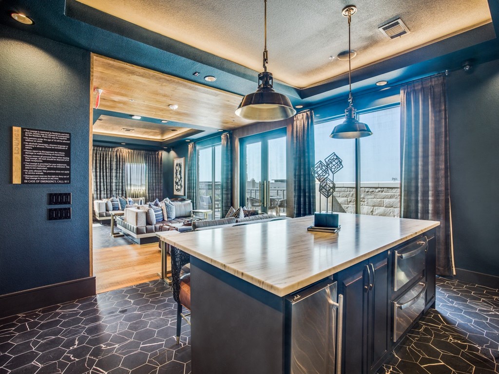 a kitchen with a large island and a living room in the background