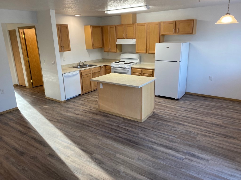 an open kitchen with white appliances and wooden cabinets