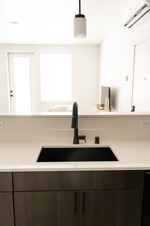 A modern kitchen with a sink and a window.