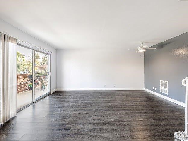 A spacious room with a sliding glass door leading to a balcony.