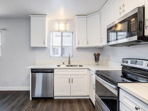 A kitchen with white cabinets and black appliances.