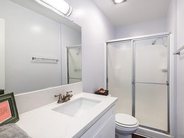 A white bathroom with a toilet, sink, and shower.
