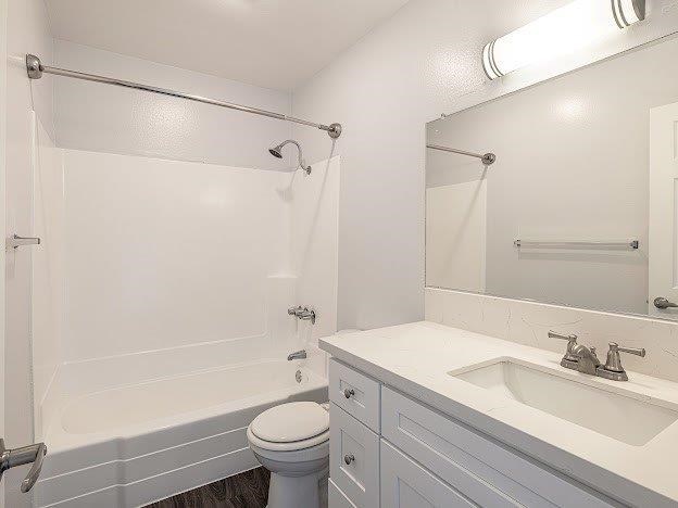A white bathroom with a toilet, sink, and bathtub.