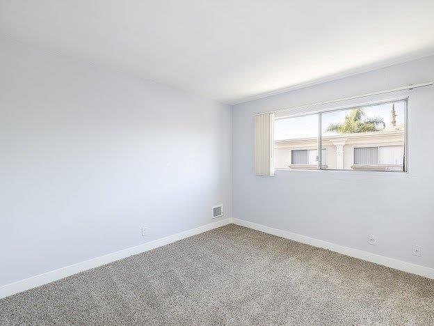 A room with a window showing a building outside.