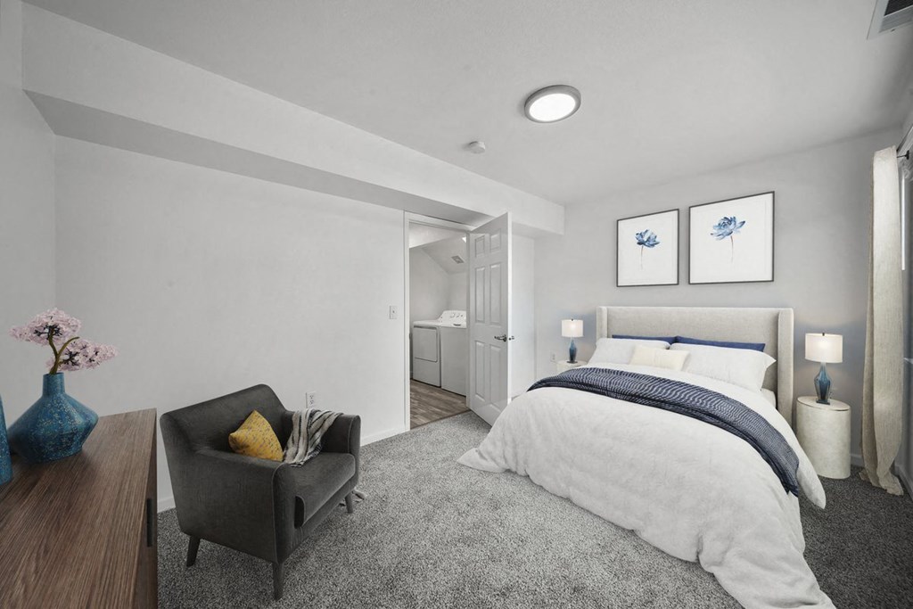 a bedroom with a medium sized bed and a chair in front of a window