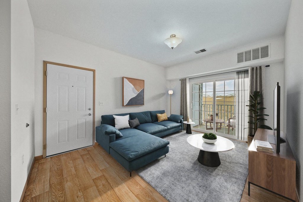a living room with a blue couch and a white coffee table