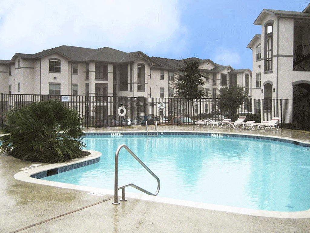 a swimming pool with an apartment building in the background