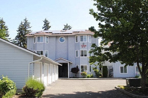 a blue house with a driveway and a garage door