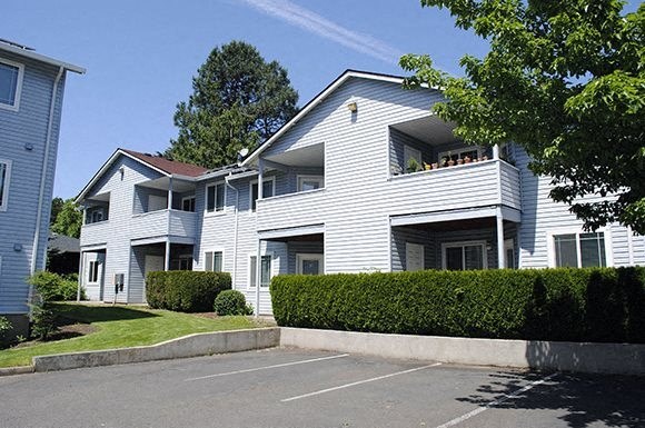 a white house with a parking lot in front of it