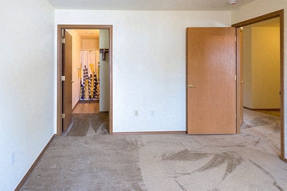 an empty living room with a door to a hallway