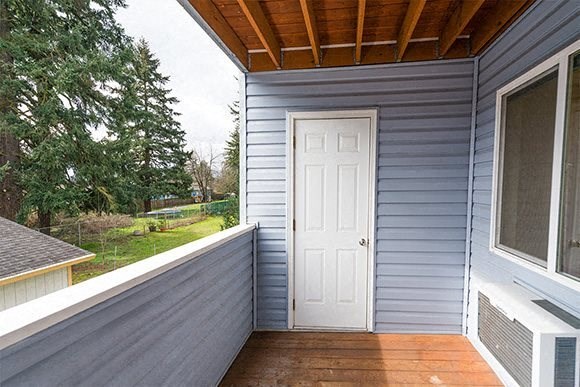 a porch with a white door on a blue house