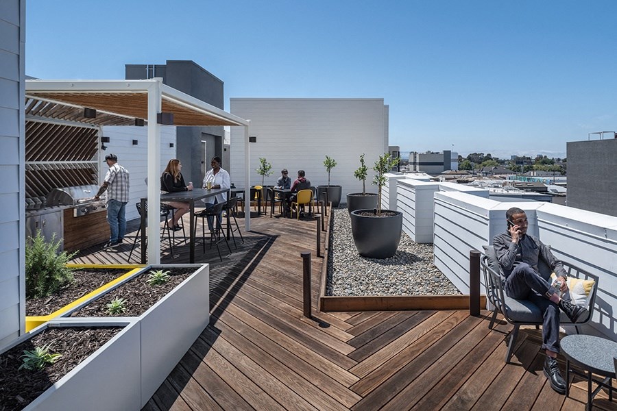 a view of the rooftop terrace with people eating and drinking on a sunny day