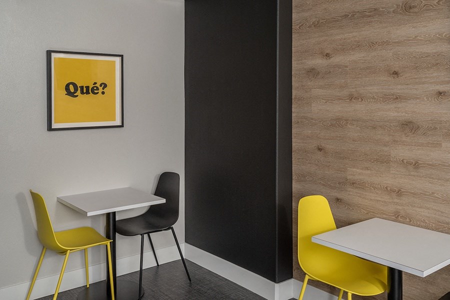 a room with two tables and two chairs with a yellow sign on the wall that says quiz